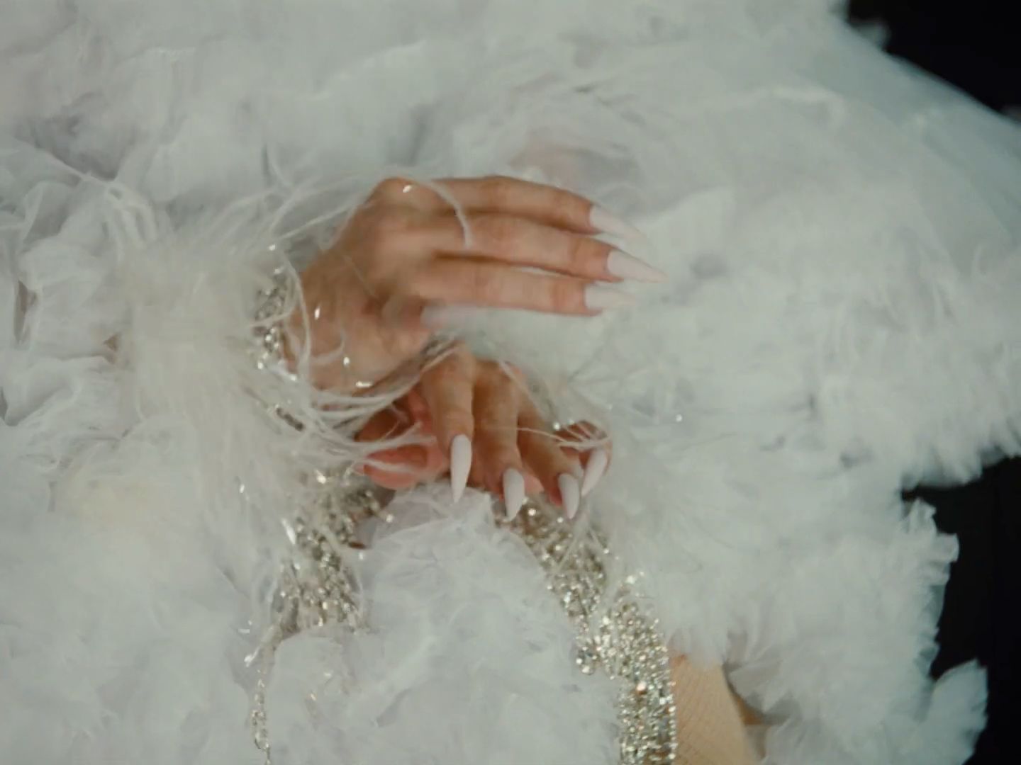 a close up of a person's hand on a white dress