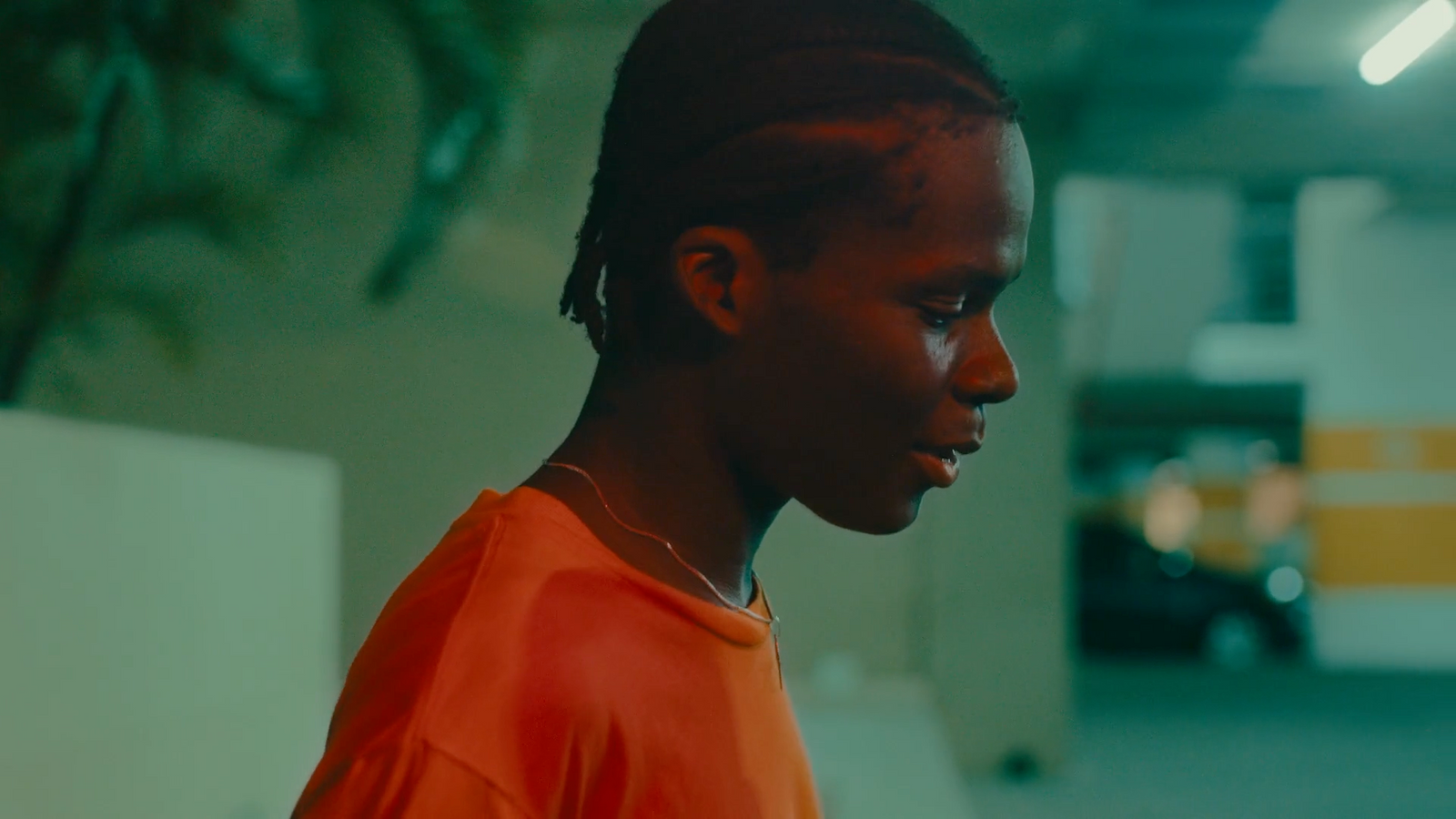 a man with dreadlocks standing in a parking garage