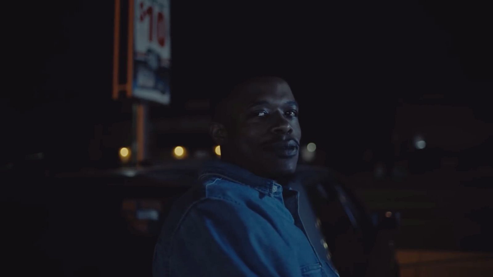 a man standing in front of a car at night