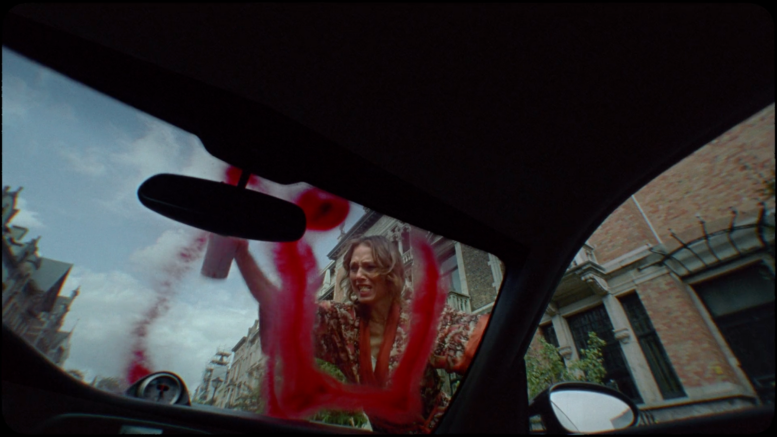 a rear view mirror of a woman in a car