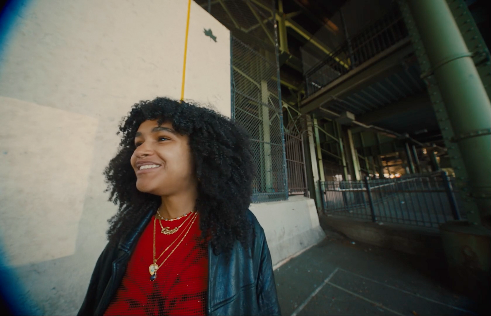 a woman with curly hair standing in front of a building