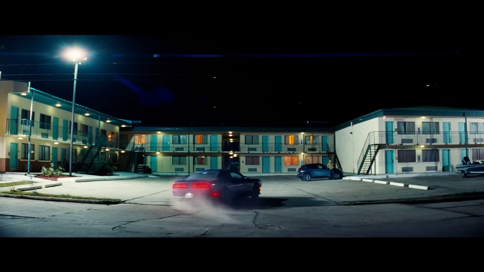 a car parked in front of a motel at night