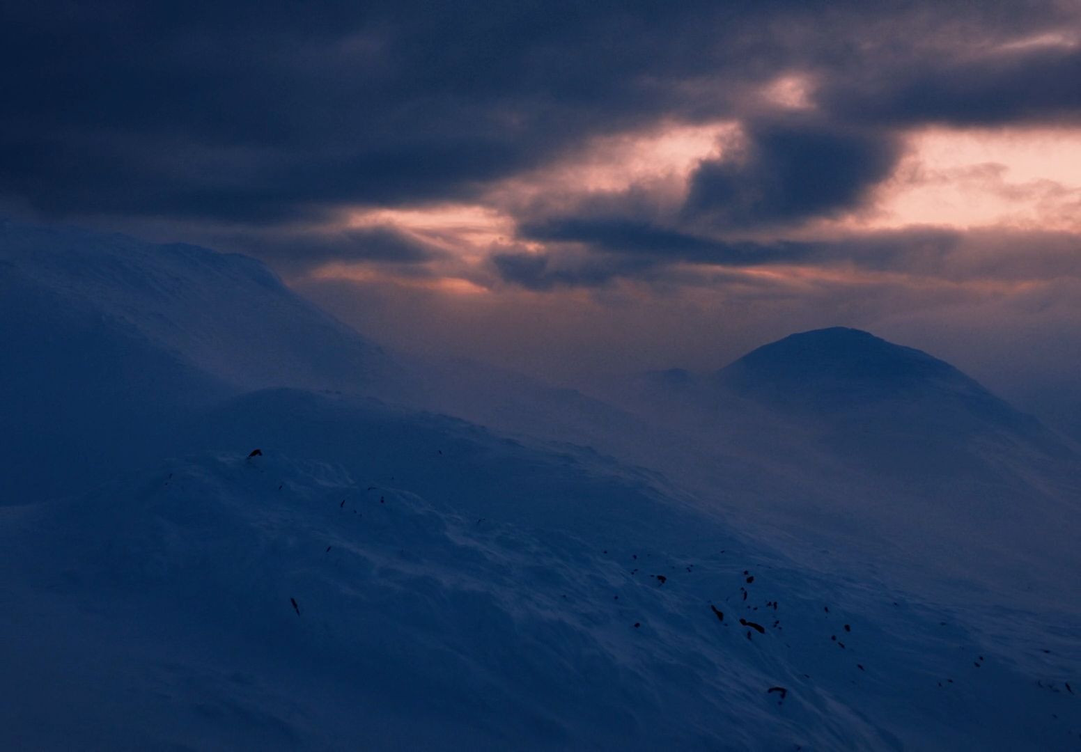 a snow covered mountain under a cloudy sky