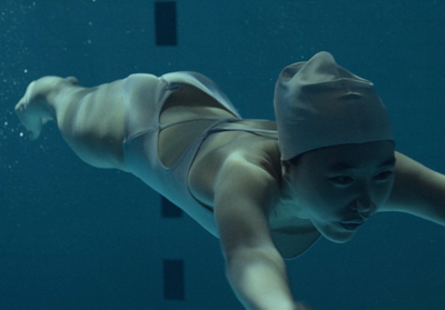 a woman in a hat swimming in a pool