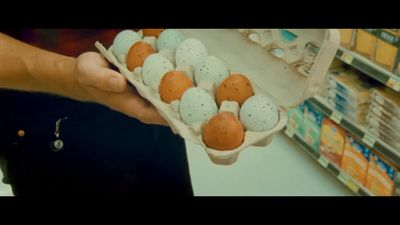 a person holding a carton of eggs in a store