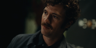 a man with curly hair and a mustache