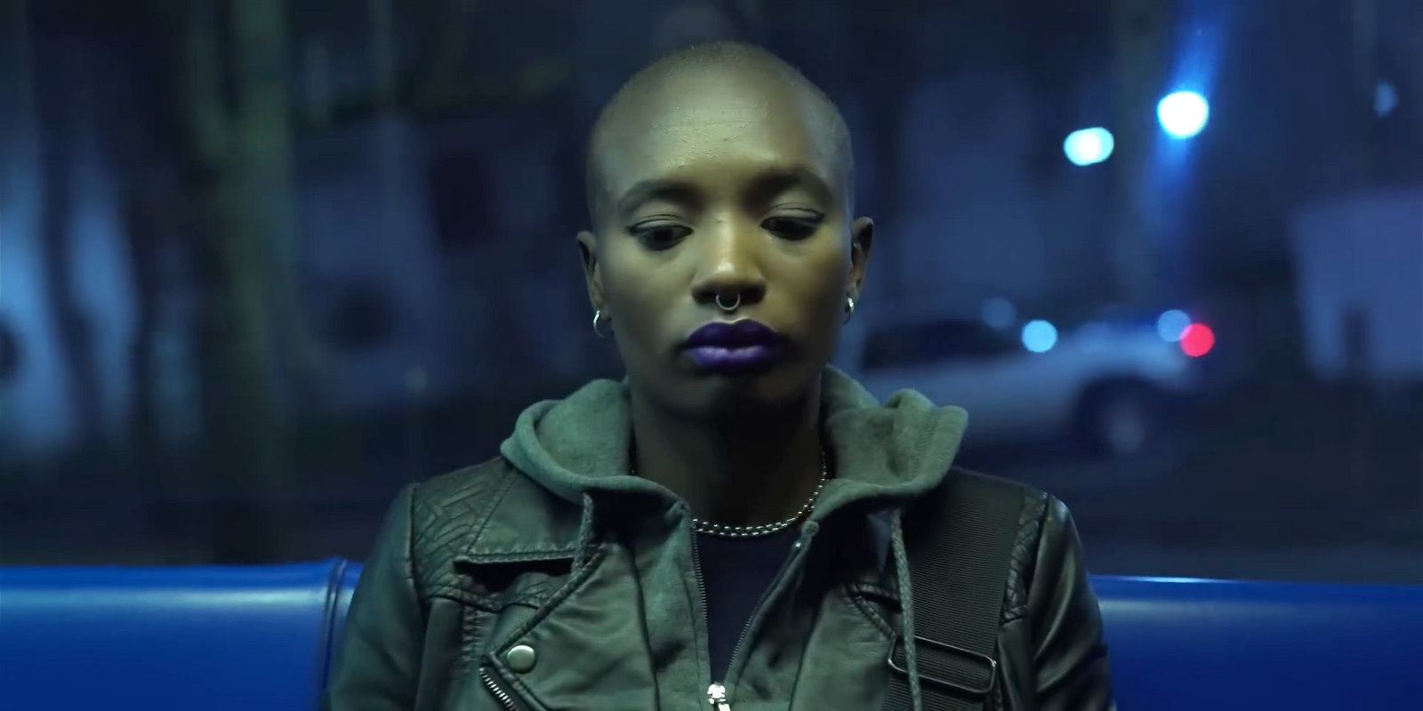 a woman with purple lipstick sitting on a blue couch