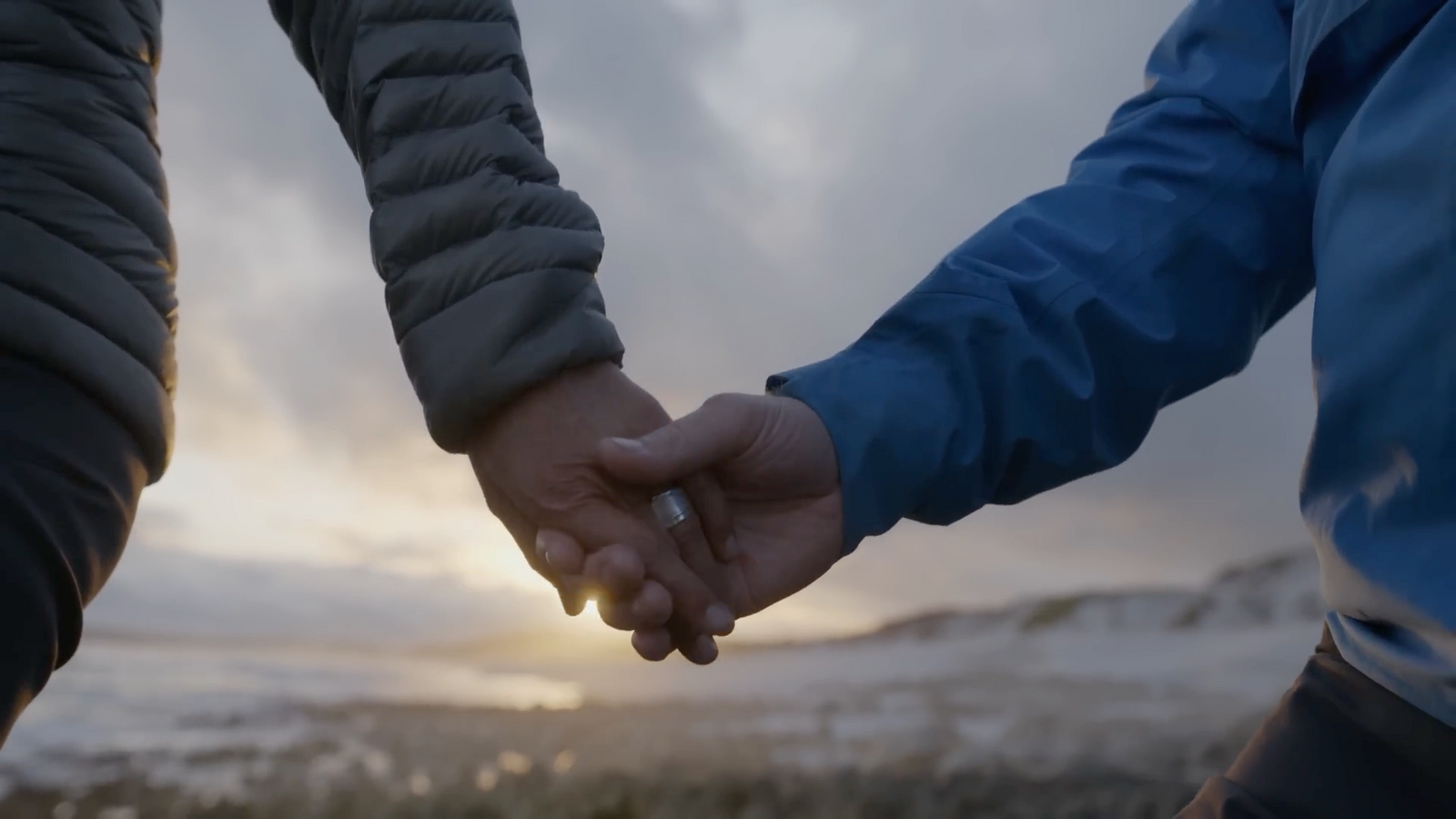 a close up of two people holding hands