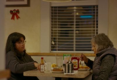 two women sitting at a table eating food