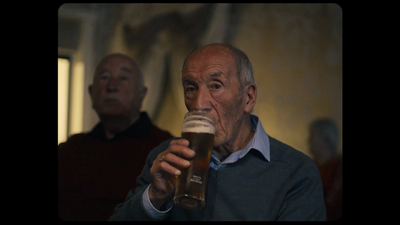 an older man drinking a glass of beer