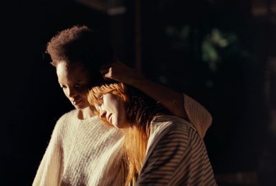 a woman is combing her long red hair