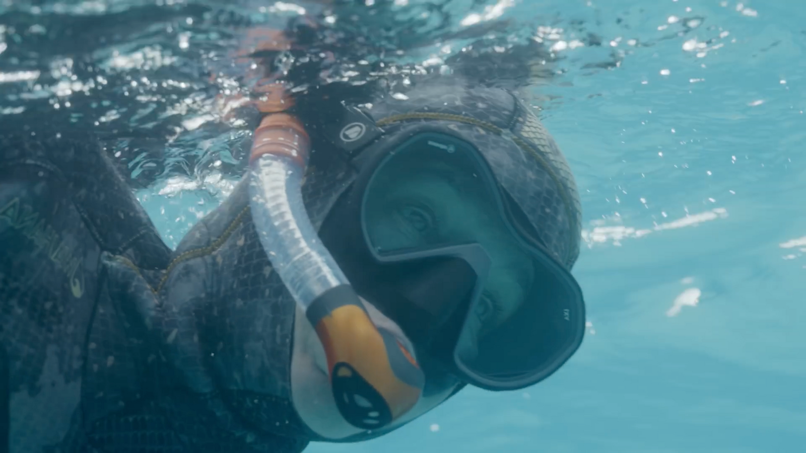 a person swimming in the water with a mask on