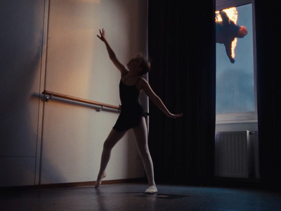 a woman in a black leotard standing in front of a window