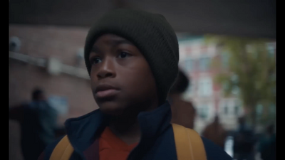 a young boy wearing a backpack and a beanie