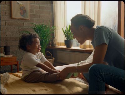 a man and a little girl sitting on a bed