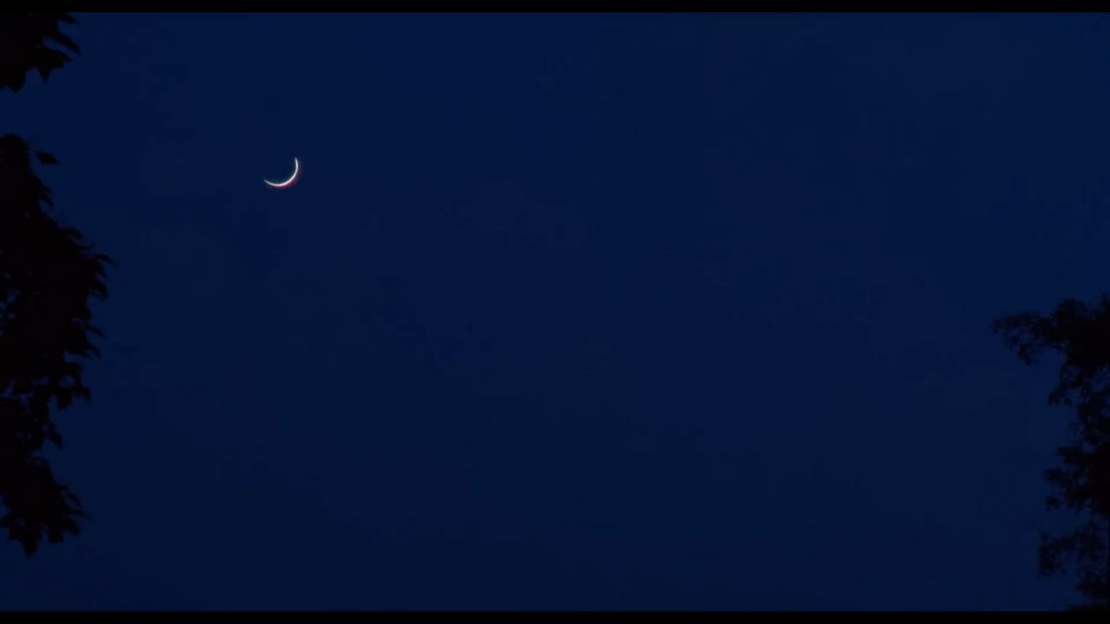 a crescent moon is seen in the night sky