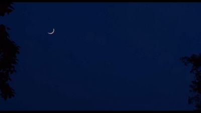 a crescent moon is seen in the night sky