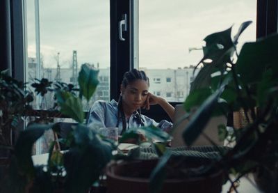 a woman sitting at a table in front of a window