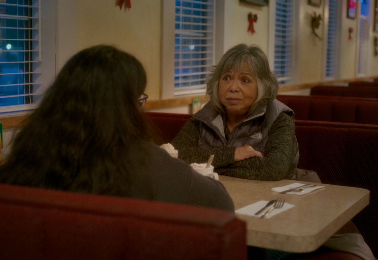 a woman sitting at a table in a restaurant