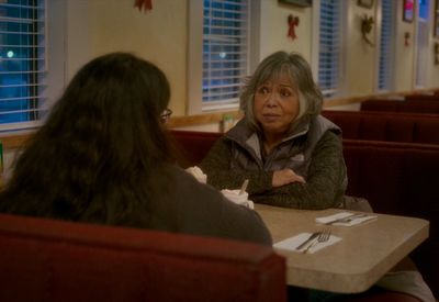 a woman sitting at a table in a restaurant