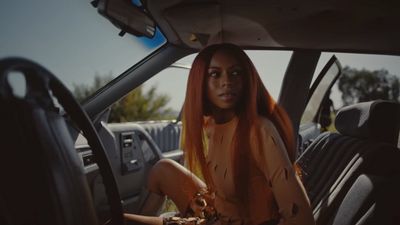 a woman with orange hair sitting in a car