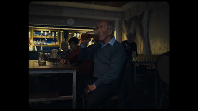 a man sitting at a bar drinking a beer