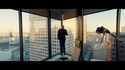 a man standing in an office looking out the window