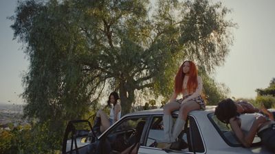 a group of people sitting on top of a car