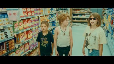 three children are standing in a store aisle