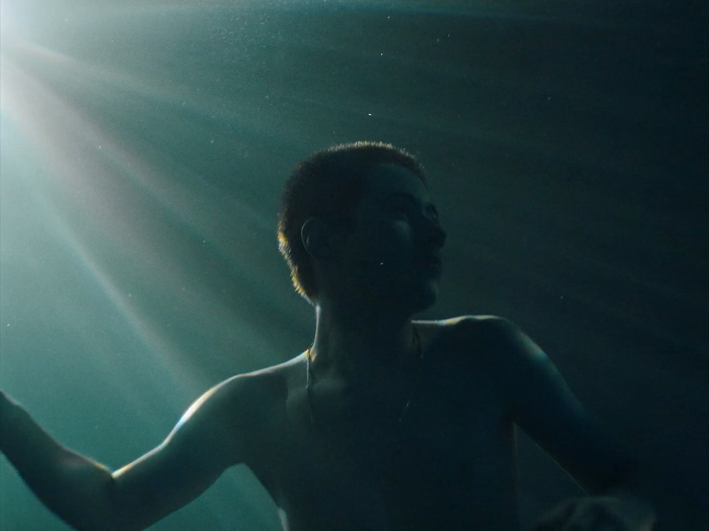 a man standing under water with his arms out