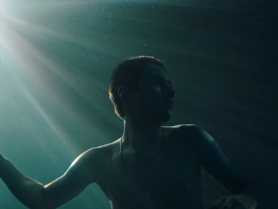 a man standing under water with his arms out