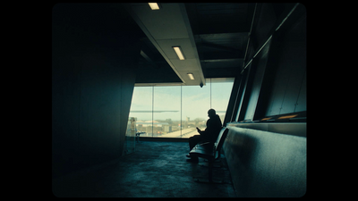 a person sitting on a bench looking out a window