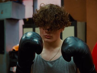 a young man wearing boxing gloves in a gym