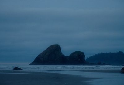 a couple of large rocks sitting on top of a beach