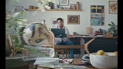 a man sitting at a desk using a laptop computer