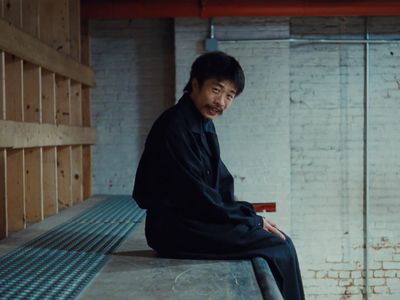 a man sitting on top of a metal bench