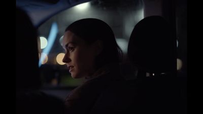 a woman sitting in the back seat of a car at night