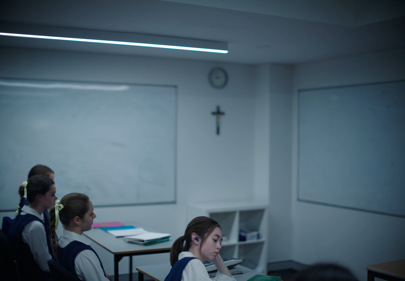 a group of girls sitting at desks in a classroom