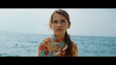 a woman standing in front of a body of water