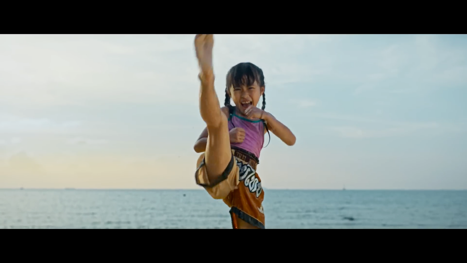 a young girl doing a handstand on the beach