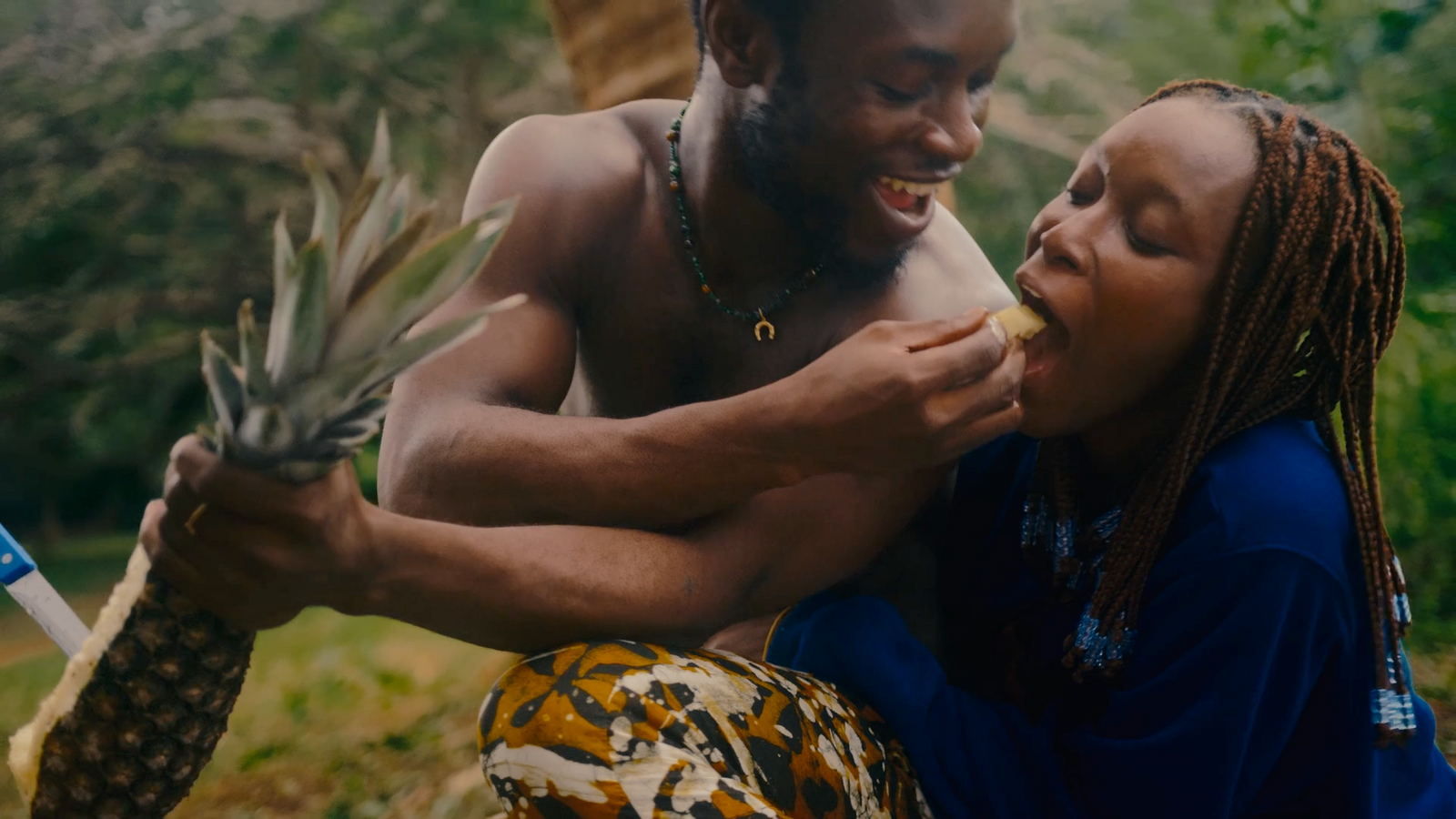 a man and a woman eating a pineapple