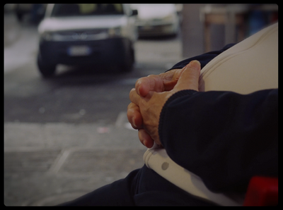 a close up of a person holding hands with a car in the background