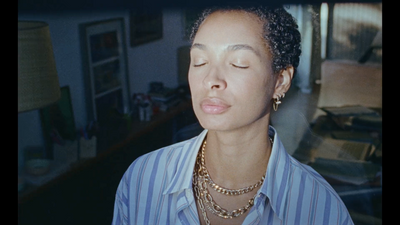 a woman with her eyes closed wearing a necklace