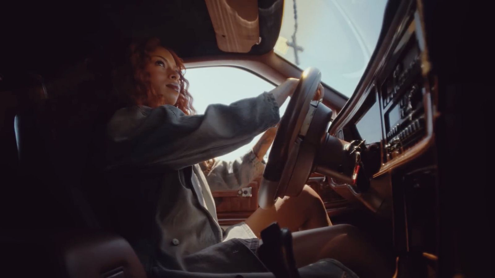 a woman sitting in the driver's seat of a truck