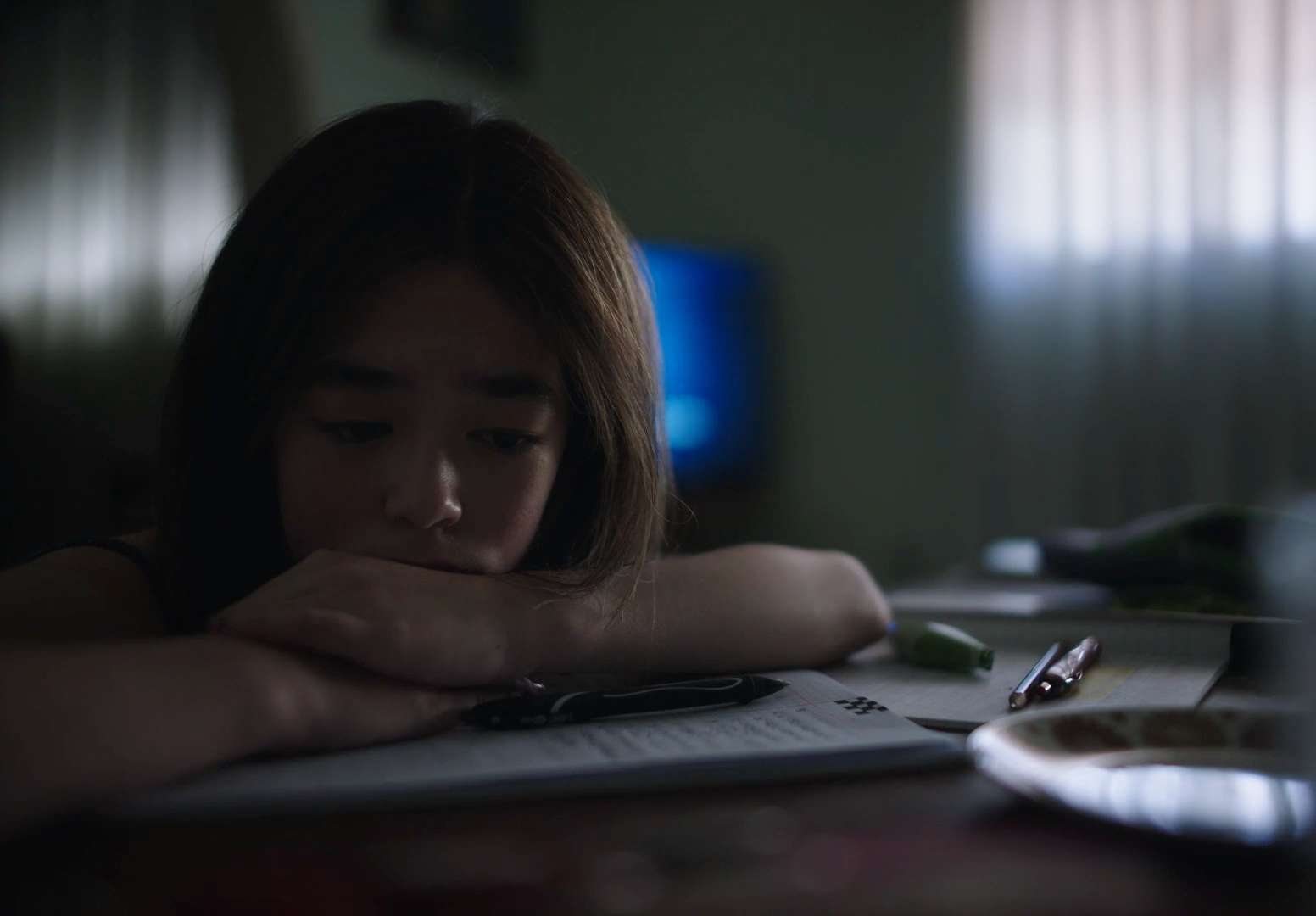 a young woman sitting at a table with a book