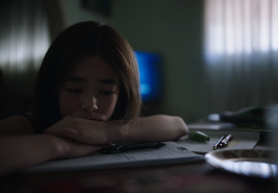 a young woman sitting at a table with a book