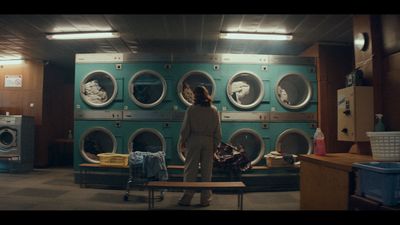 a woman standing in front of a row of washers