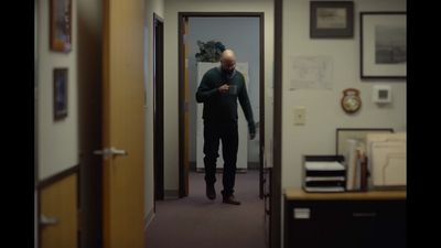 a man standing in a hallway looking at his cell phone