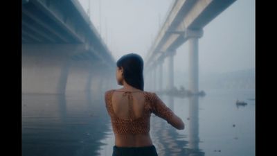 a woman standing in front of a bridge on a foggy day