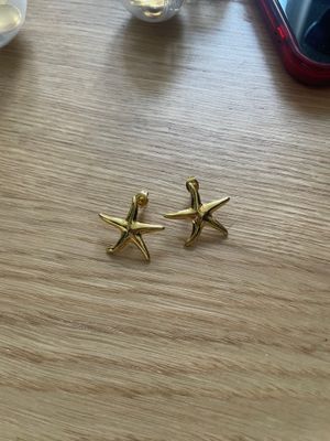 a pair of starfish earrings sitting on top of a wooden table